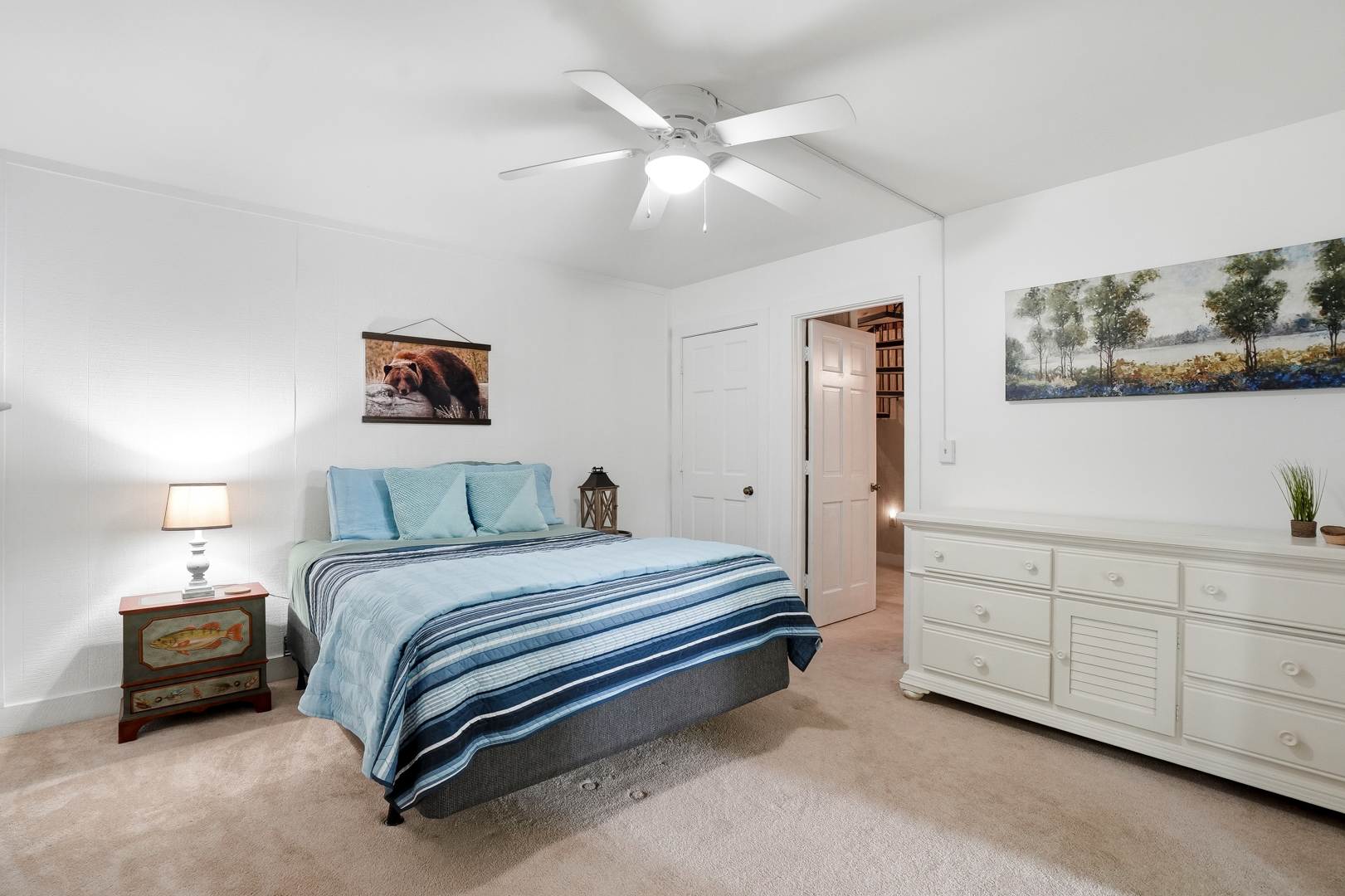 Queen bedroom with dresser and artwork